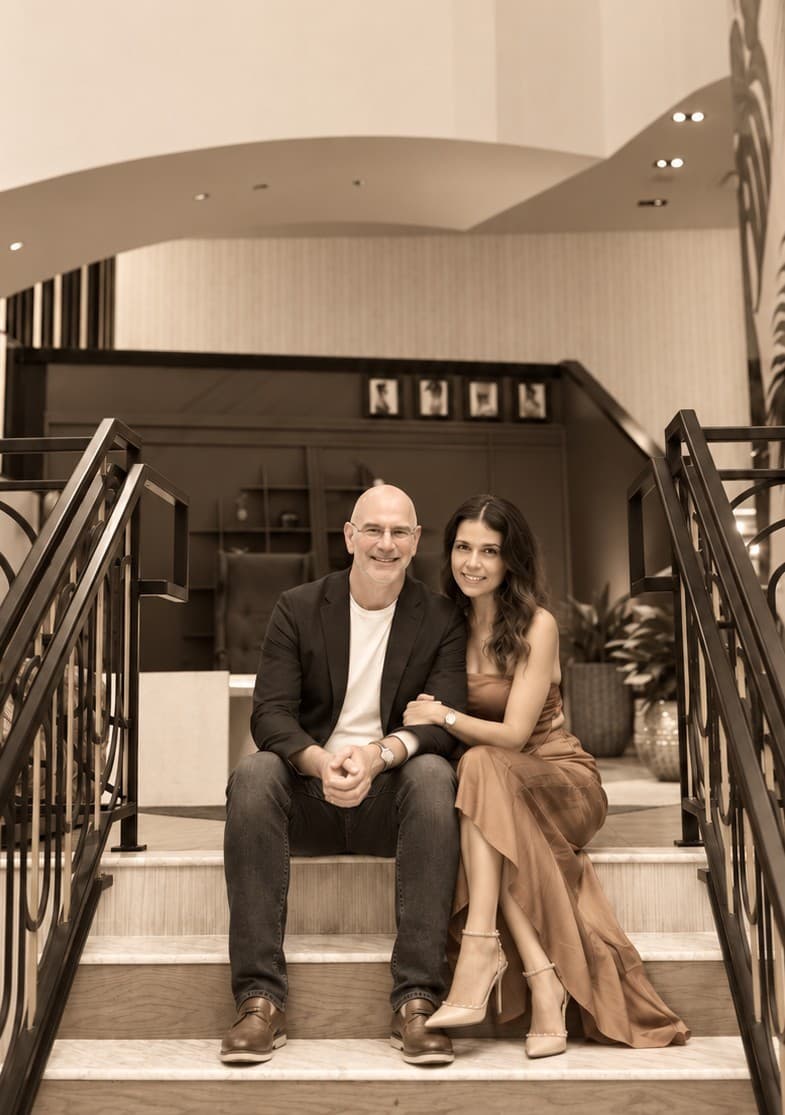 Timothy and Alejandra, the founders of Allie's, seated on a hotel staircase